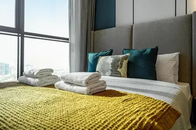 a bedroom with a bed with towels on it at Modern Studio - near Dubai Hills Mall - Pool & Gym in Dubai