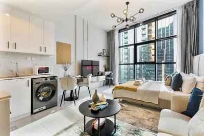 a large living room with a bed and a kitchen at Modern Studio - near Dubai Hills Mall - Pool & Gym in Dubai