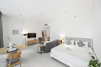 a bedroom with a bed and a living room at Modern Studio in Business Bay, Stylish & Central in Dubai