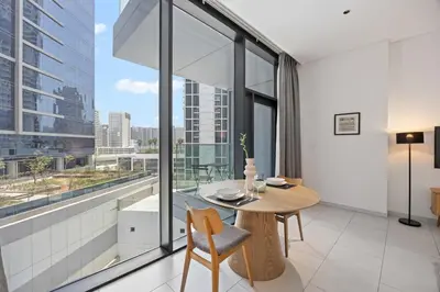 a dining room with a table and a large window at Modern Studio in Business Bay, Stylish & Central in Dubai