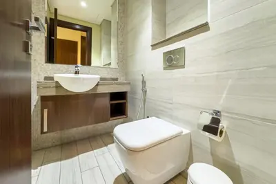 a bathroom with a white toilet and a sink at Elegant 1BR with Canal Views in Business Bay in Dubai