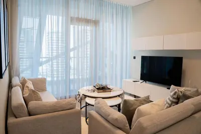 a living room with two couches and a tv at Stylish 1BR with Stunning Canal Views in Business Bay in Dubai