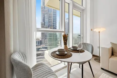 a living room with a table and chairs and a large window at BLVD - Missoni Living - Close to Burj Khalifa in Dubai