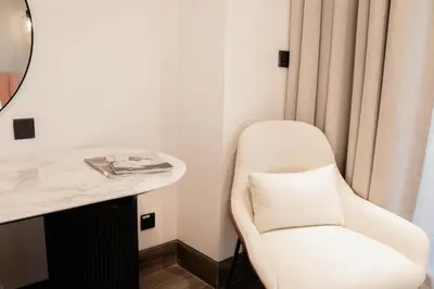 a white chair in a room with a mirror at Spacious 1BR in Business Bay l Pool, Gym & Parking in Dubai