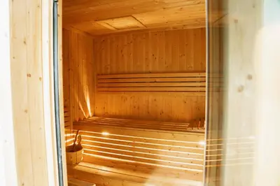a sauna with wooden walls and a glass door at Spacious 1BR in Business Bay l Pool, Gym & Parking in Dubai