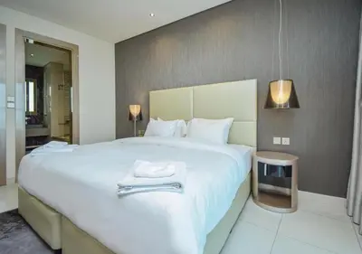 a bedroom with a large white bed with a towel on it at PARAMOUNT TOWER B BUSINESS Bay Lux 1 bedroom Apt in Dubai