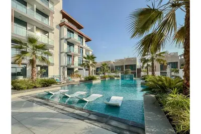 a swimming pool with lounge chairs in a building at Oxford Luxury 1 bedroom & study in Dubai