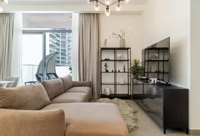 a living room with a couch and a table at Oxford Luxury 1 bedroom & study in Dubai