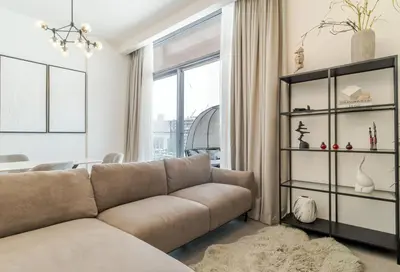 a living room with a couch and a large window at Oxford Luxury 1 bedroom & study in Dubai