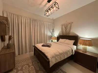 a bedroom with a bed and a large window at Cozy Apartment Dubai Silicon Arch in Dubai