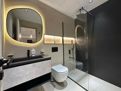 a bathroom with a toilet and a sink and a mirror at Cozy Apartment Dubai Silicon Arch in Dubai