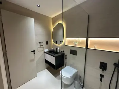 a bathroom with a toilet and a sink and a mirror at Cozy Apartment Dubai Silicon Arch in Dubai