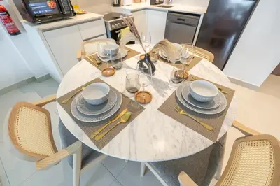 a dining table with plates and dishes on it in a kitchen at StayShort - MJL Apartment for 2 people near Water Parks in Dubai