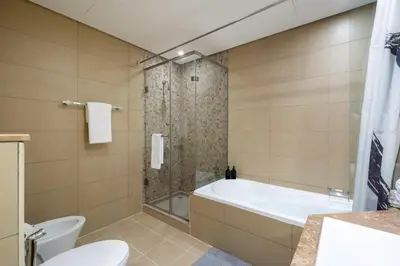 a bathroom with a tub and a toilet and a shower at Gorgeous 2BR in DIFC close to Metro & Dubai Mall in Dubai