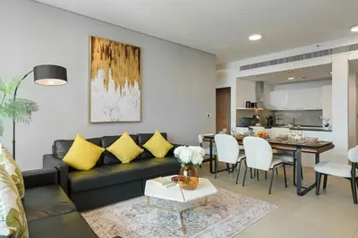 a living room with a black couch and yellow pillows at Gorgeous 2BR in DIFC close to Metro & Dubai Mall in Dubai