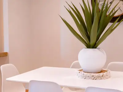 a white table with a potted plant on it at Spacious 2BR Steps from Downtown in Dubai