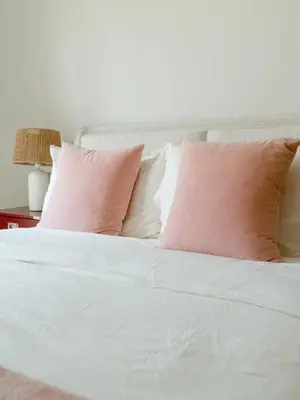 a bed with pink and white pillows on it at Spacious 2BR Steps from Downtown in Dubai
