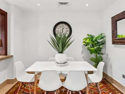 a white dining room with a white table and chairs at Spacious 2BR Steps from Downtown in Dubai