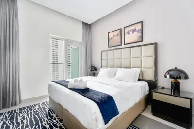 a bedroom with a large bed and a window at Downtown Dubai Studio Apartment - High floor in Dubai