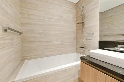 a bathroom with a white bath tub and a sink at BLVD - Stylish Missoni Stay - Canal View in Dubai