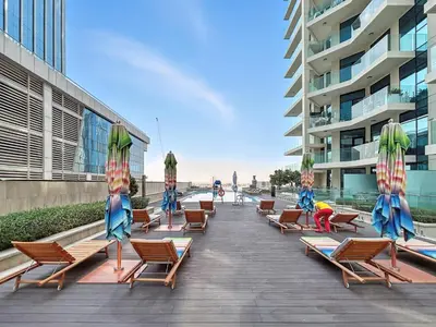 a row of beach chairs and umbrellas on a boardwalk at BLVD - Stylish Missoni Stay - Canal View in Dubai