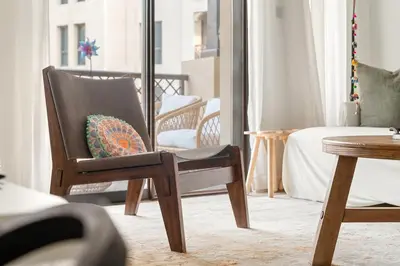 a chair with a pillow on it in a room at Dubai 2BR Pool View, Near Burj Khalifa, Canal & Attractions in Dubai