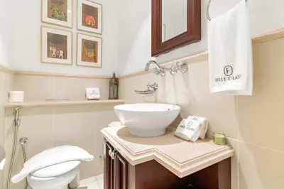 a bathroom with a white sink and a toilet at Dubai 2BR Pool View, Near Burj Khalifa, Canal & Attractions in Dubai