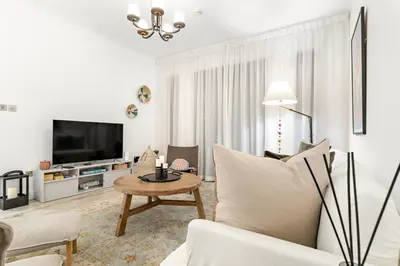 a living room with a couch and a table at Dubai 2BR Pool View, Near Burj Khalifa, Canal & Attractions in Dubai
