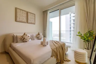 a bedroom with a large bed with a large window at Lux and Spacious 1 Bed with Beach in Dubai