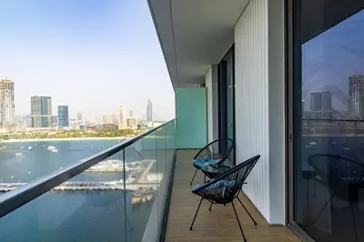 two chairs on a balcony with a view of the city at Lux and Spacious 1 Bed with Beach in Dubai