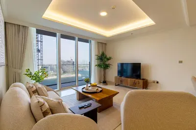 a living room with a couch and a tv at Lux and Spacious 1 Bed with Beach in Dubai