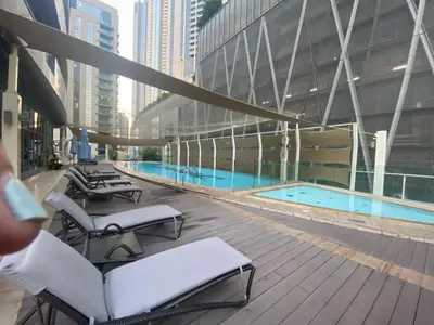 a large building with a swimming pool and lounge chairs at Elegant 2BR APT, 3 minutes to Burj Khalifa in Dubai