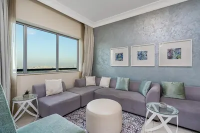 a living room with a purple couch and a large window at Elegant 2BR APT, 3 minutes to Burj Khalifa in Dubai