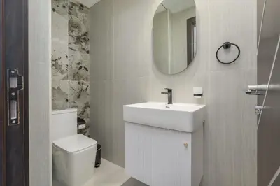 a bathroom with a sink and a toilet and a mirror at StayShort - Al Barsha Apartment Sleeps 2 with Private Balcony in Dubai