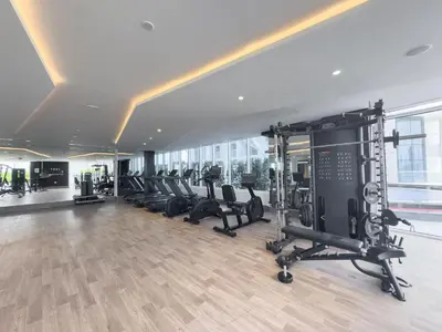 a gym with a row of treadmills and machines at StayShort - Al Barsha Apartment Sleeps 2 with Private Balcony in Dubai