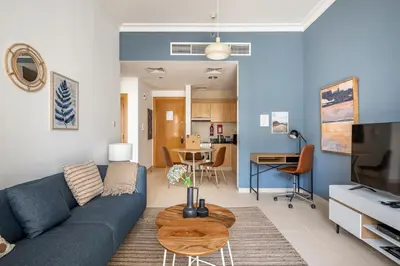 a living room with a blue couch and a table at Water View I Chic 1BR I Mayfair I 3 Sleeps I Fast Wi-Fi I Walkable Area in Dubai