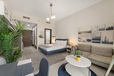 a living room with a couch and a table at Luxury Studio with Gym, Pool & Badminton Court in Dubai