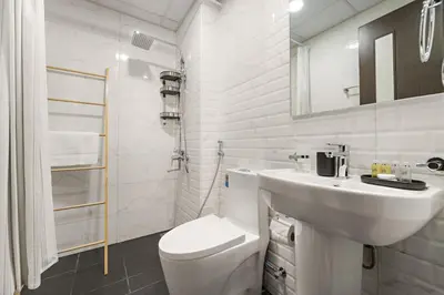 a white bathroom with a sink and a toilet at Luxury Studio with Gym, Pool & Badminton Court in Dubai