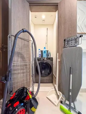 a kitchen with a mop and a washing machine at Incredibly Elegant 1BDR with full Marina Views in Dubai