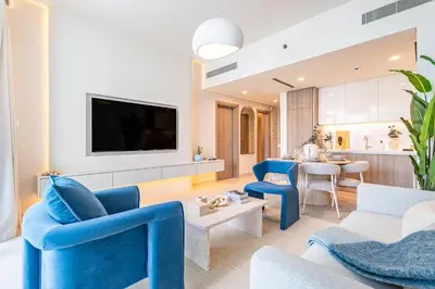 a living room with blue chairs and a tv at Incredibly Elegant 1BDR with full Marina Views in Dubai