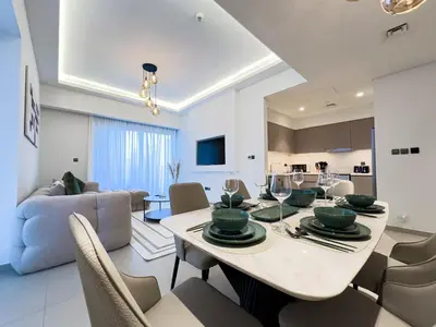 a dining room and living room with a table and chairs at Beautiful 2BR with Burj Khalifa Views in Dubai