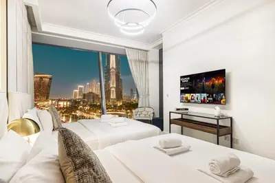 a hotel room with two beds and a large window at Luxury Burj Vista Suites by Mystique - Breathtaking Burj Khalifa Views in Dubai