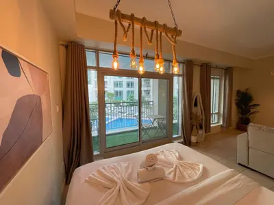 a bedroom with a bed and a large window at Cozy Studio Near Burj Khalifa Sleeps 3 in Dubai