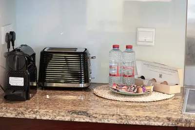 a counter with two bottles of water and a toaster at Cozy Studio Near Burj Khalifa Sleeps 3 in Dubai