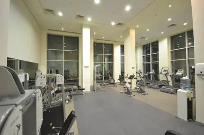 a gym with treadmills and machines in a building at Cozy Studio Near Burj Khalifa Sleeps 3 in Dubai