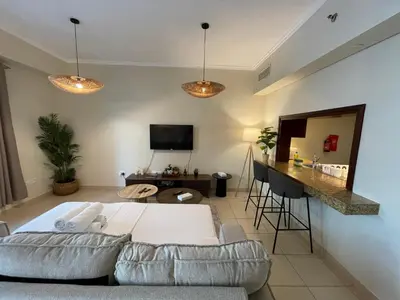 a living room with a couch and a table at Cozy Studio Near Burj Khalifa Sleeps 3 in Dubai