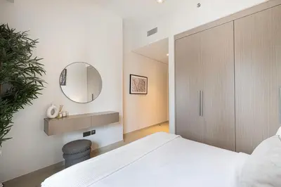 a bedroom with a white bed and a mirror at Act 1 Act 2 Towers, Luxury 4BR, Full Burj Khalifa View Balcony, Pool, Gym in Dubai