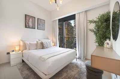 a white bedroom with a bed and a window at Act 1 Act 2 Towers, Luxury 4BR, Full Burj Khalifa View Balcony, Pool, Gym in Dubai