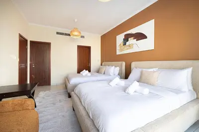 a hotel room with two beds and a couch at Stunning 2BR with Panoramic Burj & Fountain view in Dubai