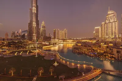 a city skyline at night with a river and buildings at Stunning 2BR with Panoramic Burj & Fountain view in Dubai